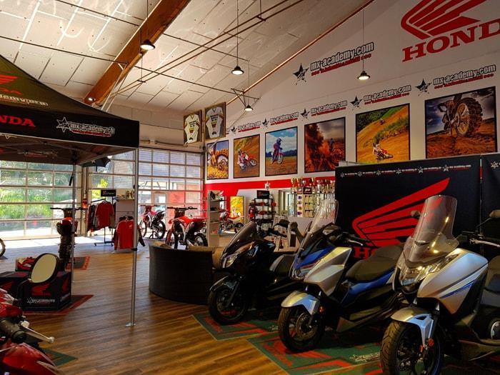 Verkaufsraum des Honda Motoshops mit Rollern, Motorrädern und Motocross Bildern