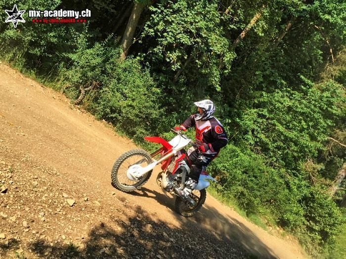 Motocross Fahrer im Team-Training auf einer Waldpassage mit Erdboden